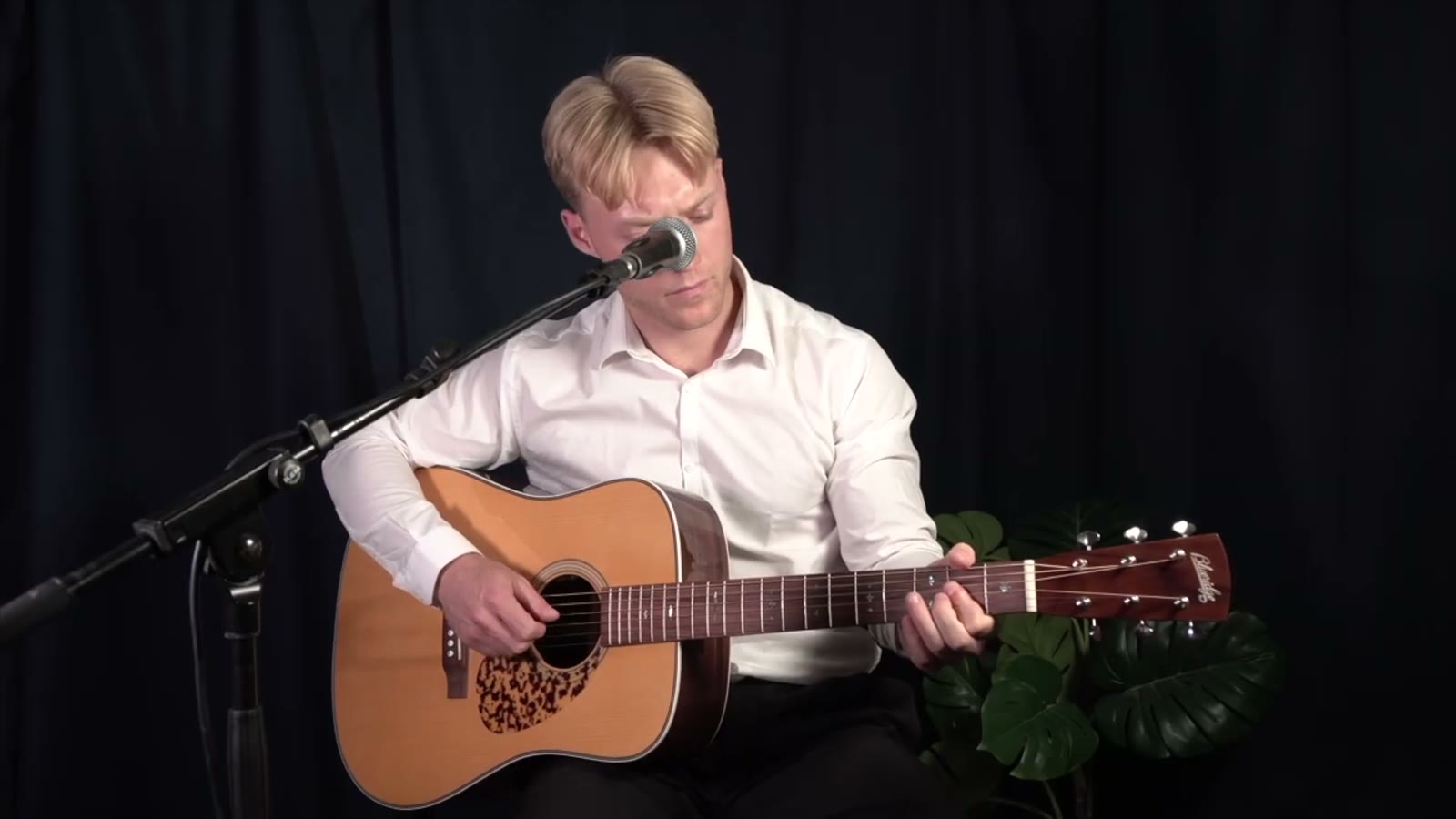 Oscar Jønsson spiller akustisk guitar i studiet